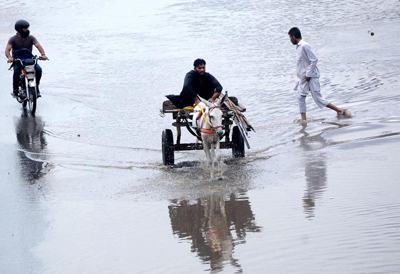 A motorcyclist passing through water accumulated on road during heavy rain that experienced the city