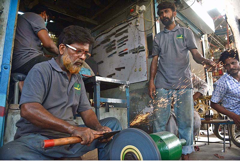 Blacksmith at Juna Market sharpens knives (to be used for slaughtering sacrificial animal) in connection with Eidul Azha