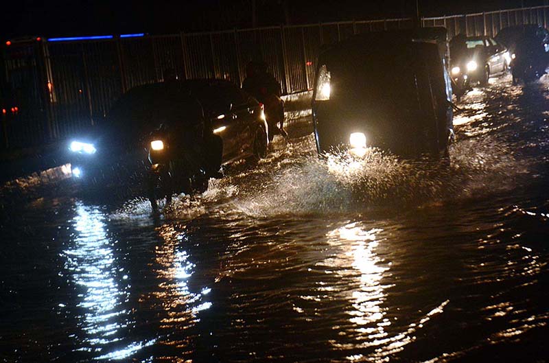 Vehicles are passing through rain water accumulated on road after heavy rain in the Provincial Capital