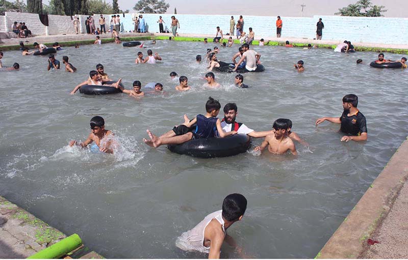 Youngsters enjoy jumping and bathing in a pond to beat the heat at the eastern bypass area of the city