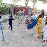 Children enjoying swing at roadside