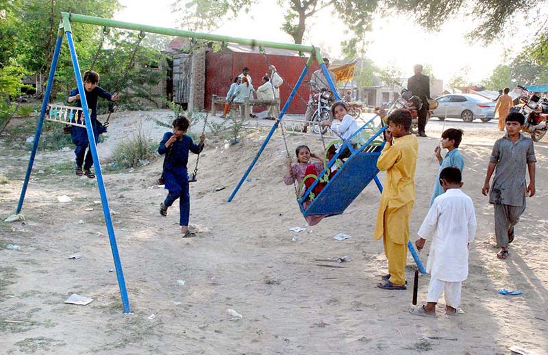 Children enjoying swing at roadside