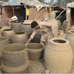 An artisan busy in making traditional oven (Tandoor) at his workplace in the outskirt area of Provincial Capital