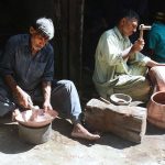 Workers busy in making antique brass and copper utensils at their shop