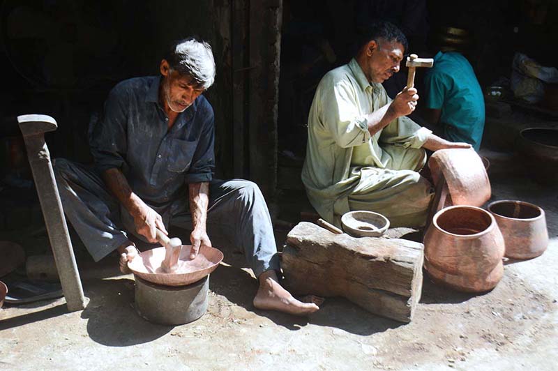 Workers busy in making antique brass and copper utensils at their shop