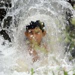 A youngster enjoying a bath in a stream to get relief from hot weather at Inqilab Road Musazai area