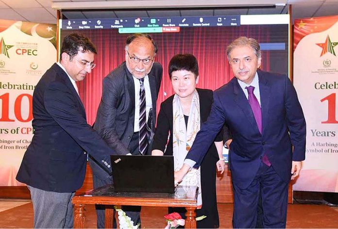 Federal Minister for Planning, Development and Reform Ahsan Iqbal and Chinese Ambassador for Pakistan H.E. Ms. Pang Chunxue press the button to perform Curtain-Raiser Event Celebrating 10Years of CPEC at Auditorium Ministry PD&SI