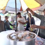 A vendor selling traditional summer drink at his roadside setup during hot weather in Provincial Capital