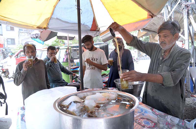 A vendor selling traditional summer drink at his roadside setup during hot weather in Provincial Capital