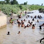 A large number of youngster bathing in Khesana Mori Canal to get some relief from hot weather in the city