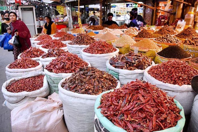 Women selecting and purchasing spices at Akbari Market
