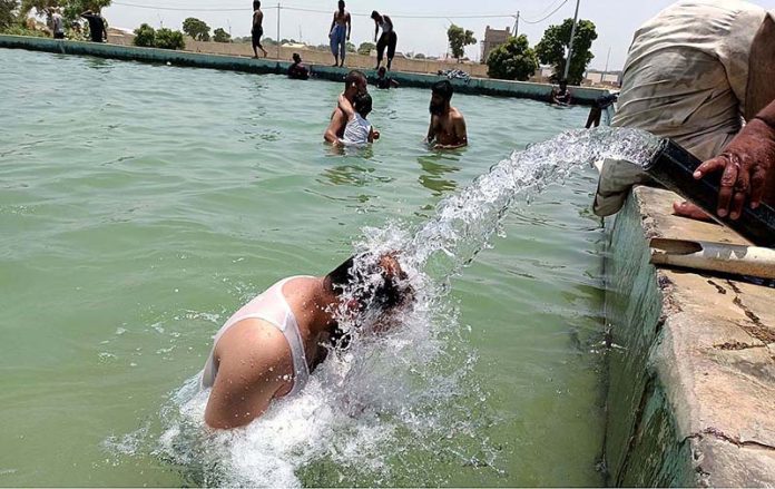 Youngster taking bath in a pool to get some relief from hot weather in the city