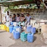 People filling their pots with drinking water from hand pump due to shortage of water in the area