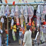 Vendors displaying colourful garlands for decorating sacrificial animals to attract the customers at a shop