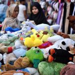 Vendors are displaying and selling used toys on their handcart at roadside setup near Mayo Hospital