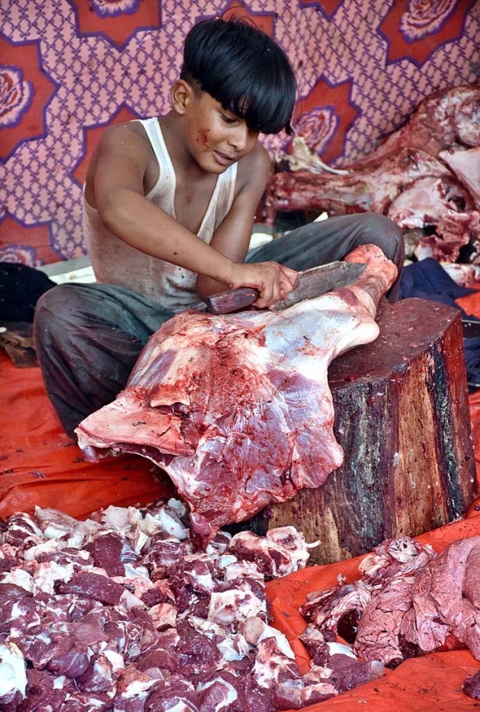 Butchers busy in slaughtering sacrificial animal on the 1st day of Eid ul Azha