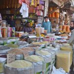 A shopkeeper waits for the customers to sell pulses at his shop in Akbari Mandi in Provincial Capital