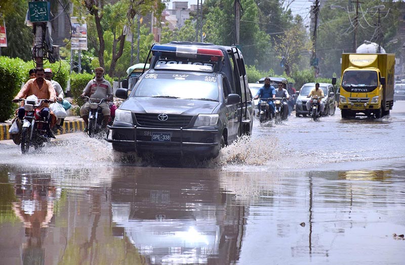 Vehicles are passing through water accumulated on road after heavy rain in the city