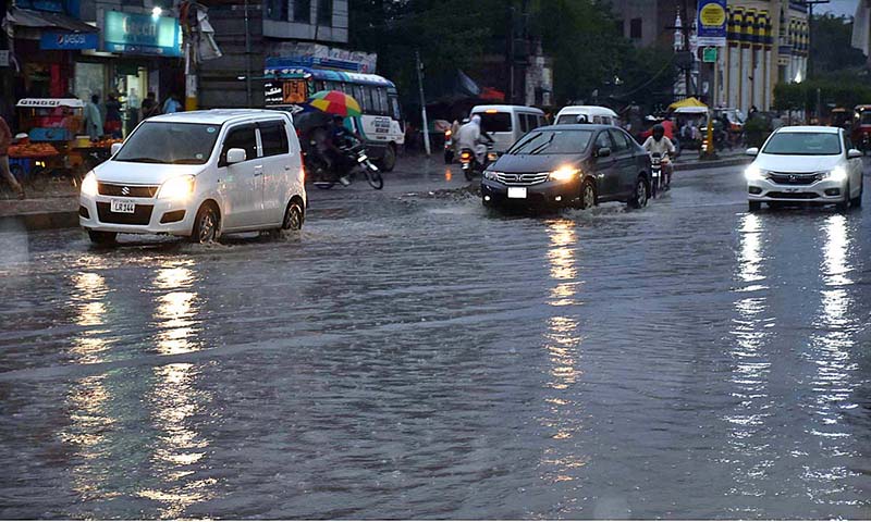 Vehicles are passing through accumulated water on road during heavy rain in the city