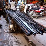 A labourer pushing handcart loaded with iron rods to deliver in a local market outside Dehli Gate in Provincial Capital