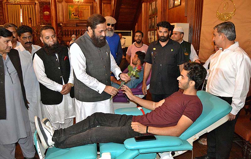 Governor Punjab Balighur Rehman presenting a flower to blood donor during blood donation camp organized by Sundas Foundation on the occasion of World Blood Donor Day at Governor House