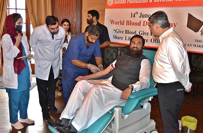 Governor Punjab Balighur Rehman presenting a flower to blood donor during blood donation camp organized by Sundas Foundation on the occasion of World Blood Donor Day at Governor House