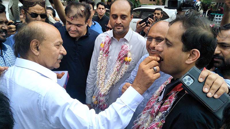 PPP Sindh President Nisar Khuhro presents sweets to Mayor-elect Murtaza Wahab on his victory at Arts Council.