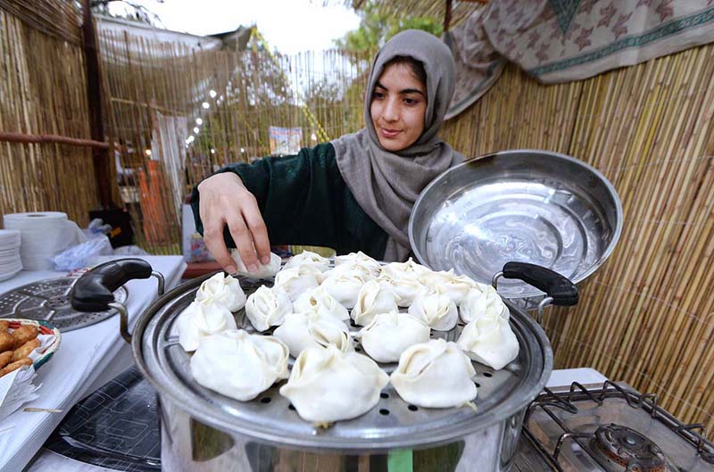 A girl from Gilgit-Baltistan preparing dumpling (a traditional dish locally called Mantu) during Saqafati Mela at Lok Virsa