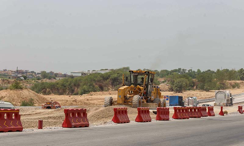 Heavy machinery being used to expand lanes for smooth traffic on Islamabad Expressway