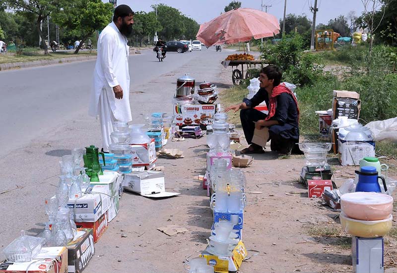 A vendor selling crockery at his roadside setup in the Federal Capital