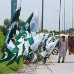 A vendor displaying flags and other 14th August related stuff to attract customers at Islamabad Expressway