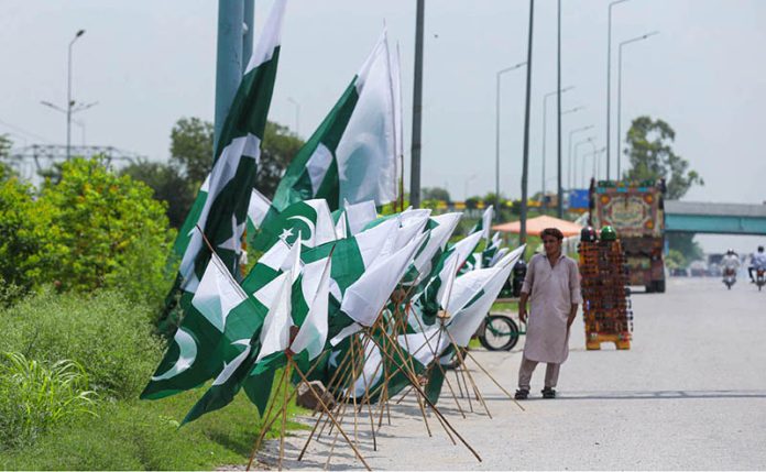 A vendor displaying flags and other 14th August related stuff to attract customers at Islamabad Expressway
