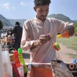 A vendor sells Ice Gola in a hot day at Shah Faisal Masjid