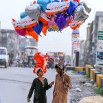 Street vendors on the way carrying different shapes balloons while looking for customers at Ghouri Town