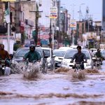 Vehicles on the way being driven through flooded streets at Ghouri Town