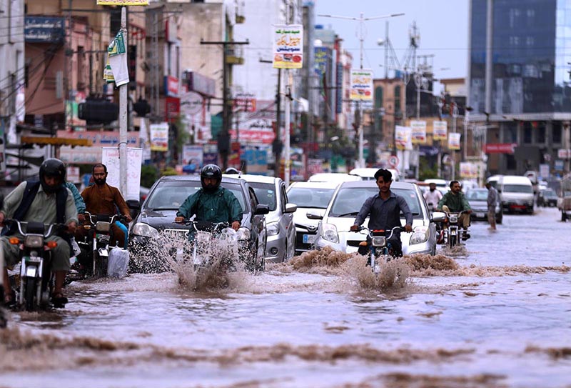 Vehicles on the way being driven through flooded streets at Ghouri Town