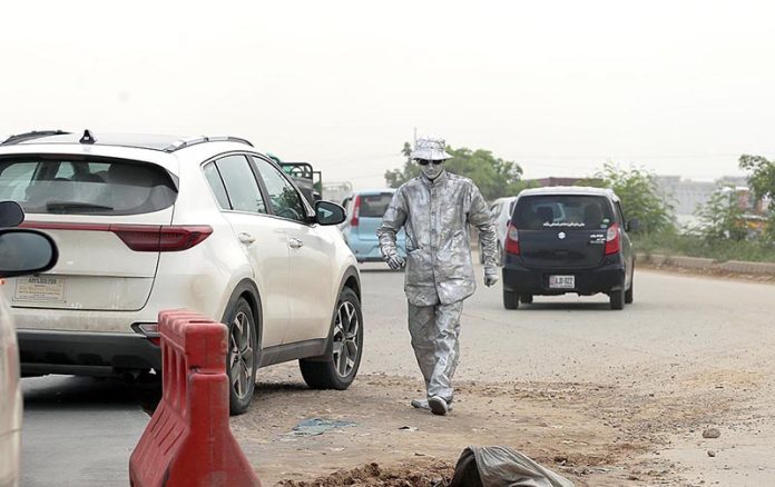 A Silver man standing on the roadside at PWD Islamabad Expressway