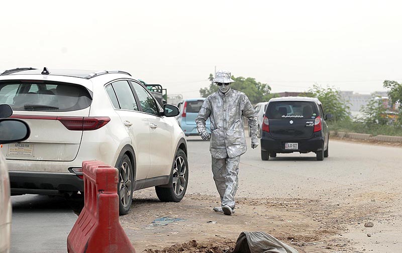 A Silver man standing on the roadside at PWD Islamabad Expressway