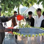 A vendor sells lamonade in a hot day at Shah Faisal Masjid