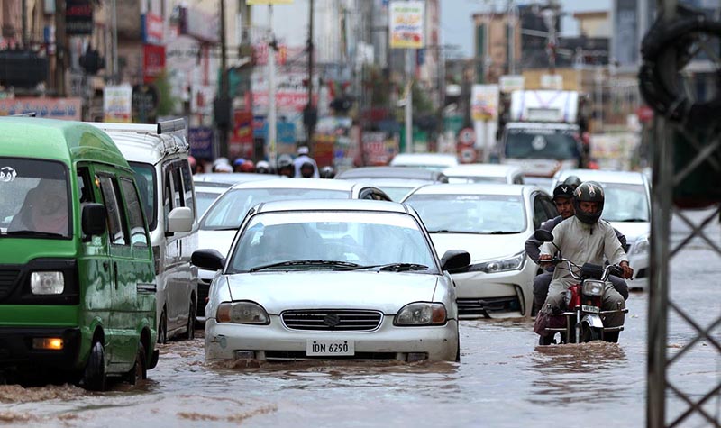 Vehicles on the way being driven through flooded streets at Ghouri Town