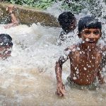 Youngster enjoying in the tub-well water tank to get relief from scorching hot weather in the city