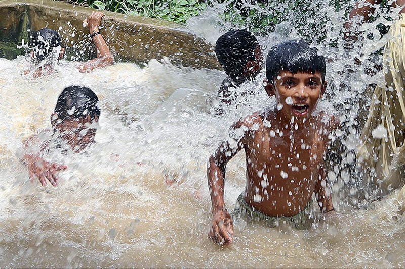 Youngster enjoying in the tub-well water tank to get relief from scorching hot weather in the city