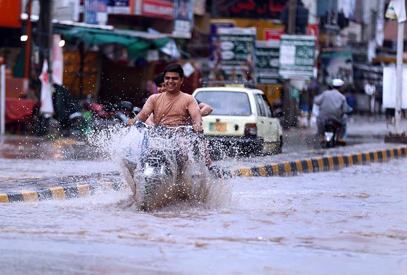Vehicles on the way being driven through flooded streets at Ghouri Town