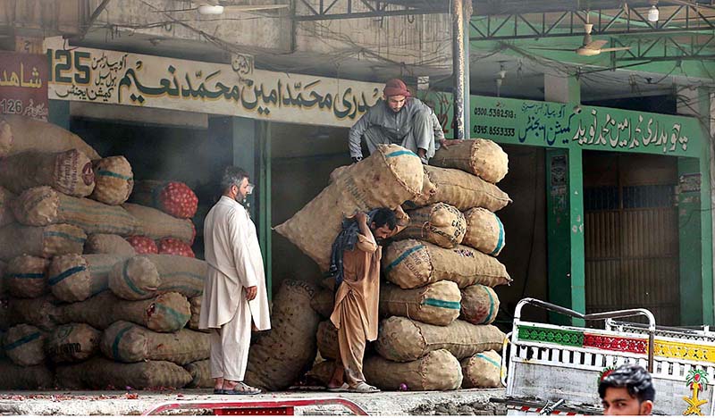 A labourer loading sack of onion on delivery vehicle at Islamabad Fruit and Vegetable Market