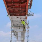 A painter busy in painting a pedestrians bridge on Islamabad Expressway