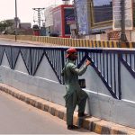 Labourer busy in coloring on the flyover wall at Nishtar road