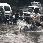 A motorcyclist passing through rain water accumulated on the IJP Road during heavy rain