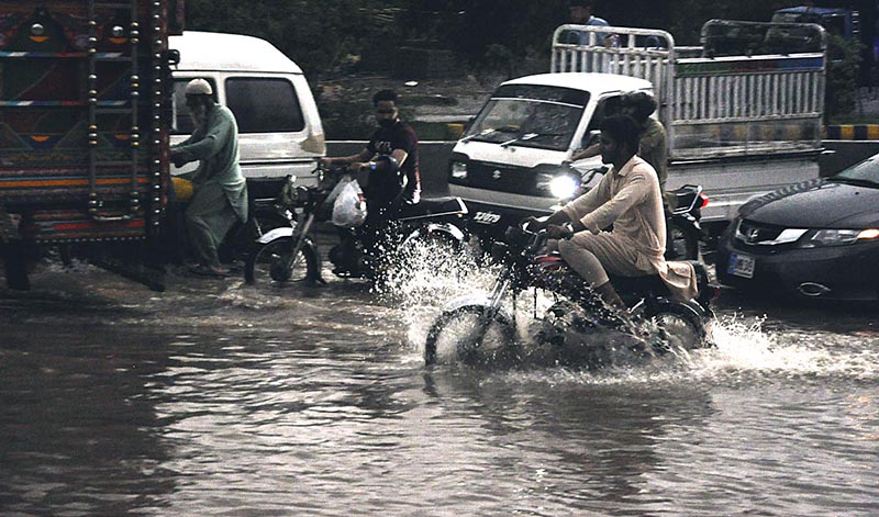 A motorcyclist passing through rain water accumulated on the IJP Road during heavy rain