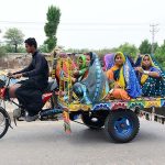 Villager women are traveling on the tricycle rickshaw heading towards their destination