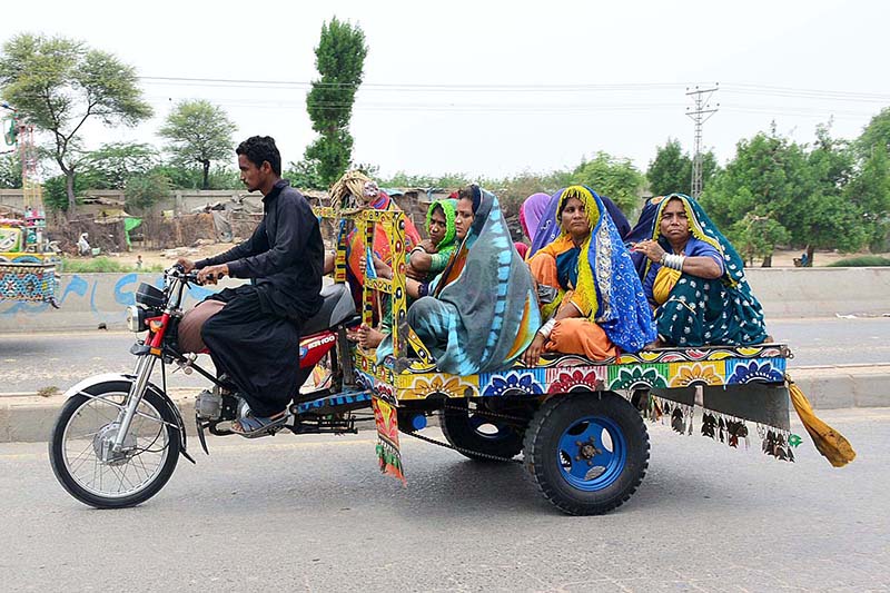 Villager women are traveling on the tricycle rickshaw heading towards their destination